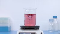 Red cell culture medium being prepared in a beaker with a magnetic stirrer.