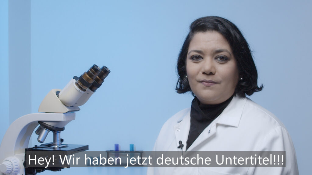 girl smiling in white lab coat with microscope 